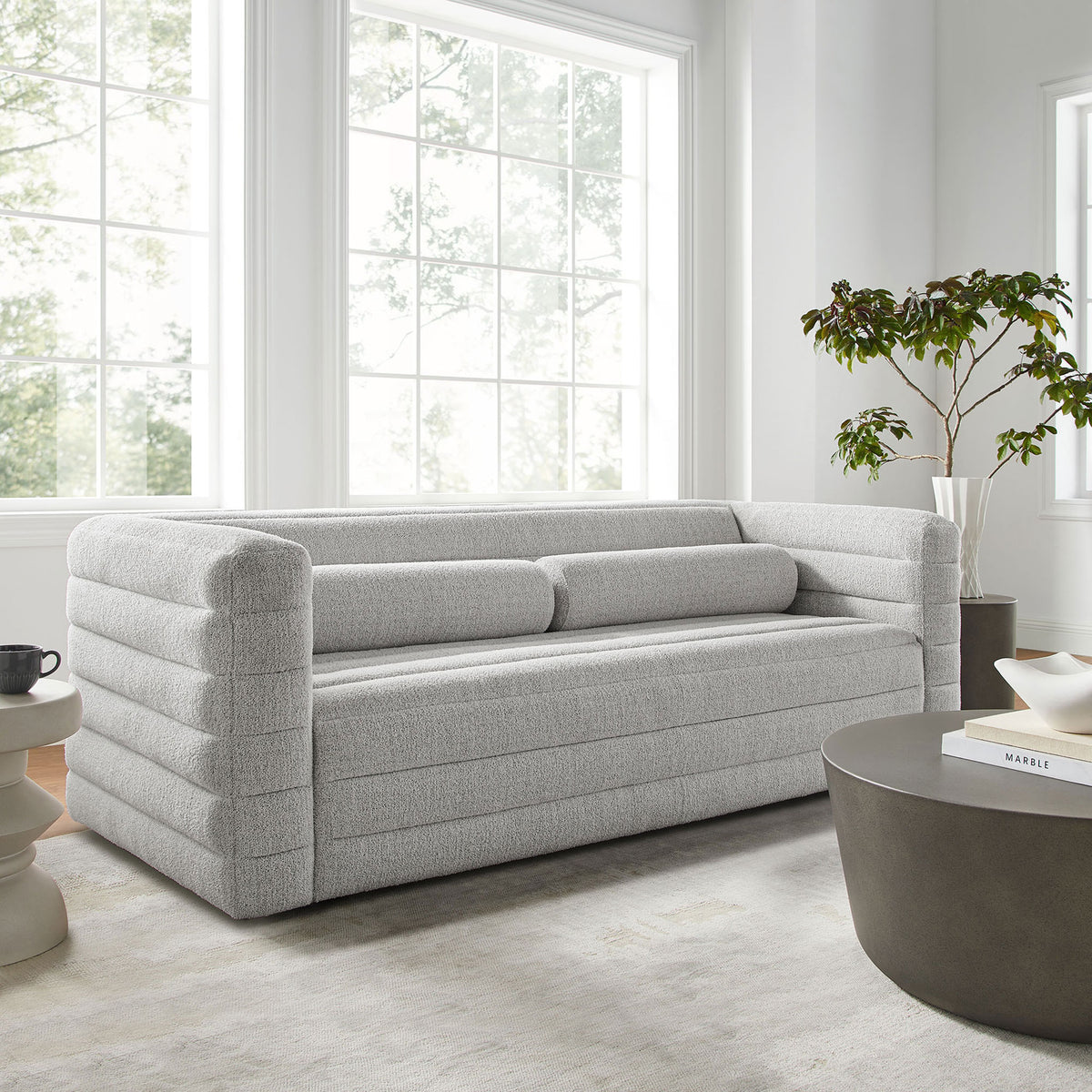 Relle channel-tufted boucle sofa styled in a bright modern living room with soft rug and sculptural tables || EEI-7136-NPT || front_angle_room