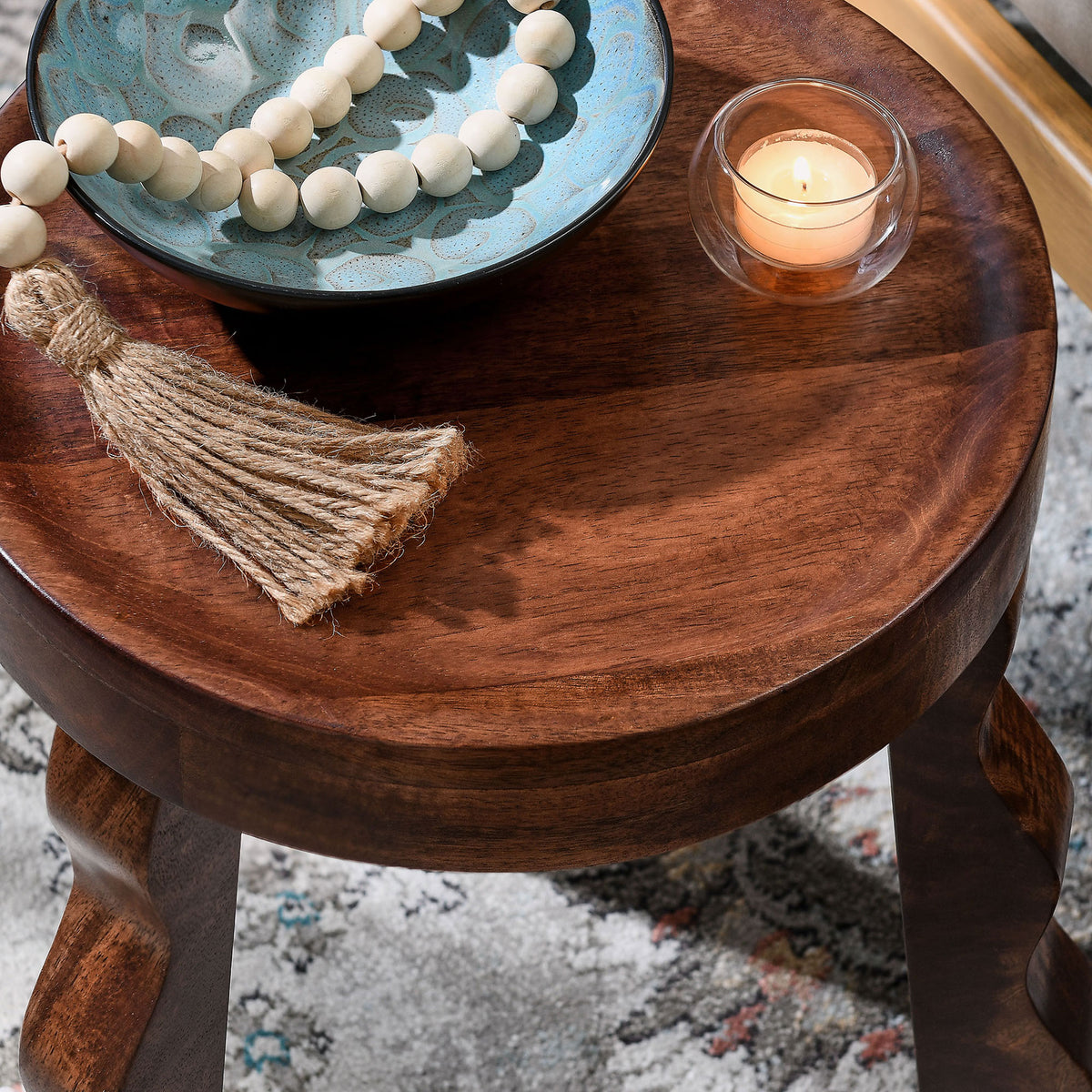 Stool top styled with decor accents on a patterned rug || EEI-7140-WAL || detail_room