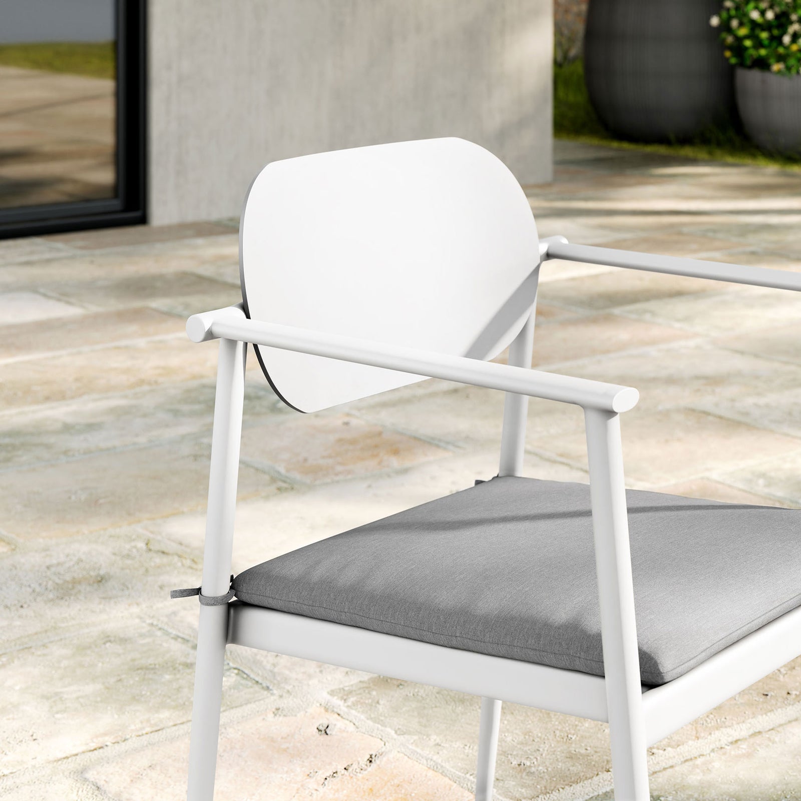 Close up of white patio armchair backrest, slim arms, and cushioned seat on a modern stone terrace || EEI-7148-WHI-LGR || detail_room