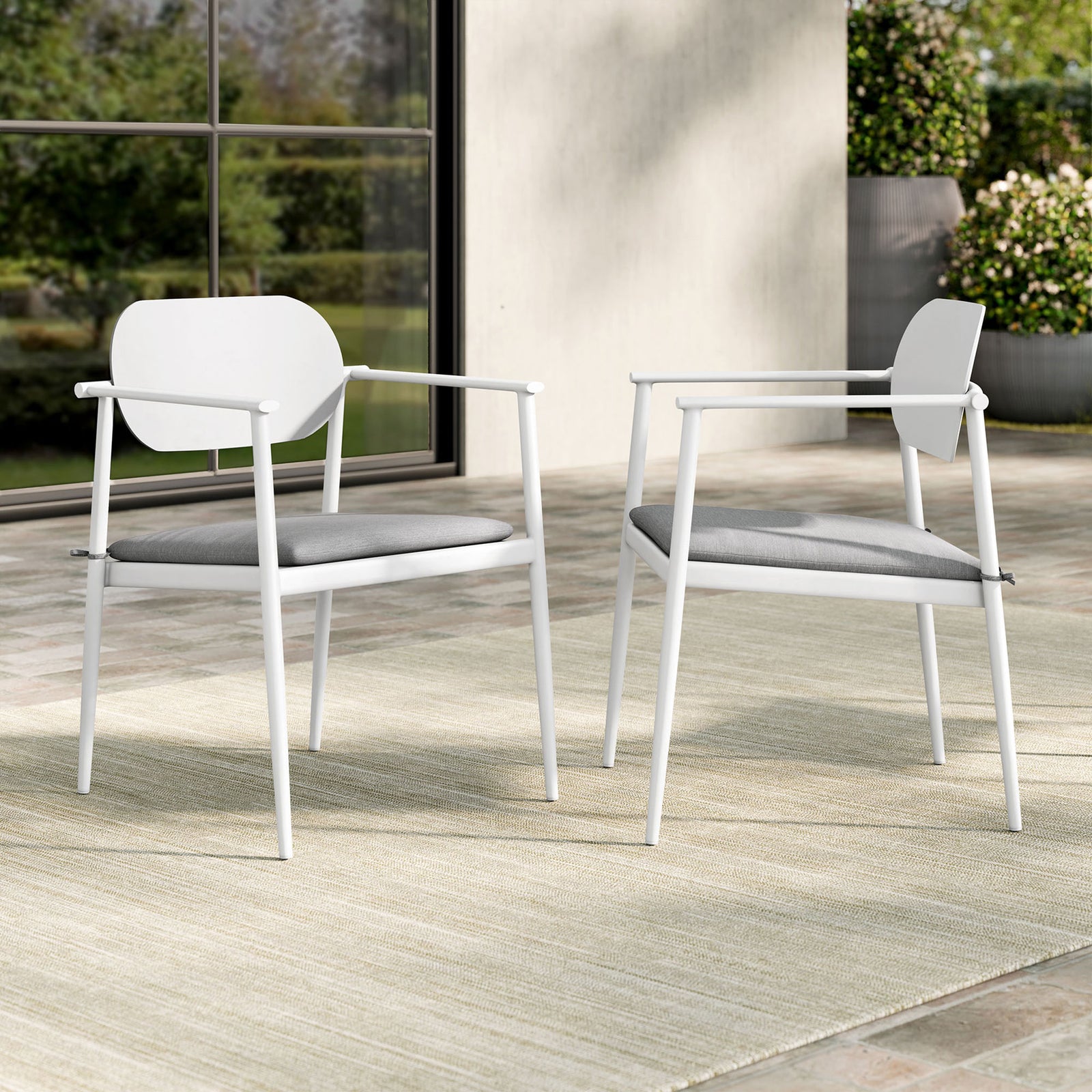 Set of two white patio armchairs with light gray cushions arranged on an outdoor terrace for relaxed dining || EEI-7148-WHI-LGR || front_angle_multi_room