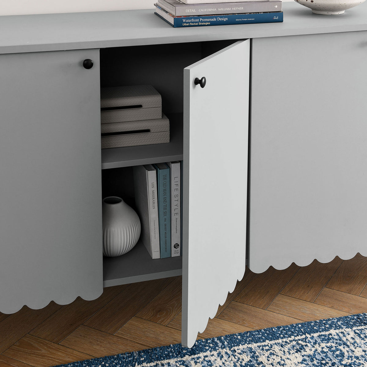 Cabinet door swings open to reveal styled shelves for books and decor, adding functional storage to modern living || EEI-7153-LGR || storage_open_room