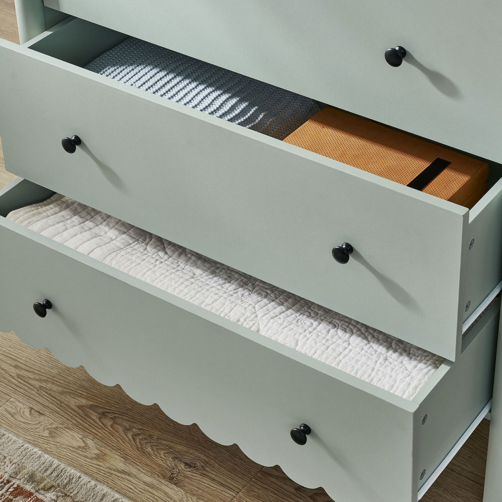 Drawers of the Emmeline chest neatly storing blankets and boxes in a cozy bedroom setting || EEI-7156-SGE || storage_open_room