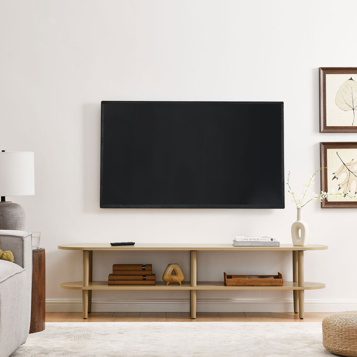 Light oak oval TV stand anchoring a modern living room under a wall mounted flat screen TV || EEI-7158-OAK || front_room