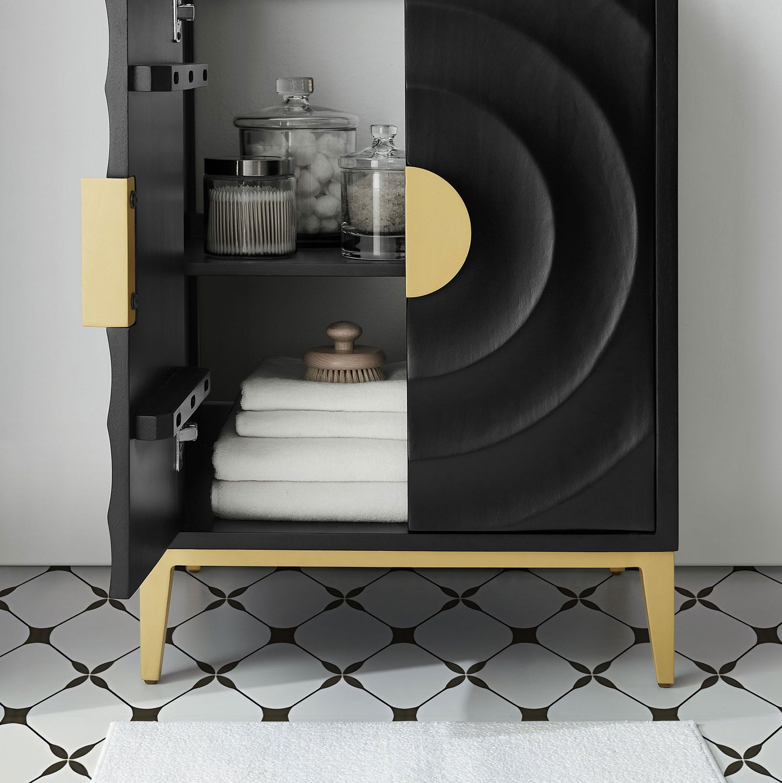 Open cabinet reveals adjustable shelving for towels and jars, framed by sculpted doors and gold legs. || EEI-7160-BLK-BLK || storage_open_room