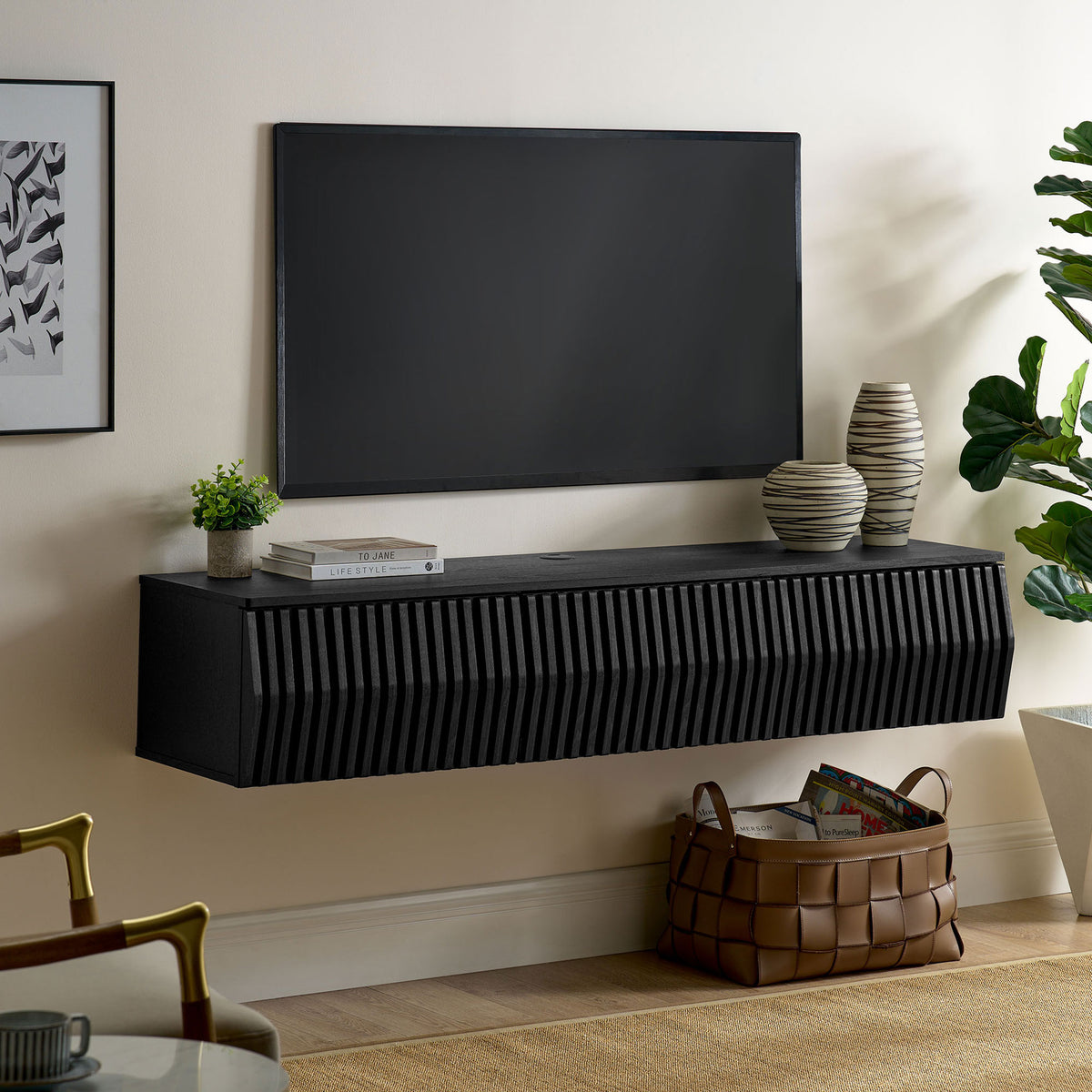 Black floating TV console installed beneath a wall-mounted screen in a contemporary living room || EEI-7164-BLK || front_angle_room