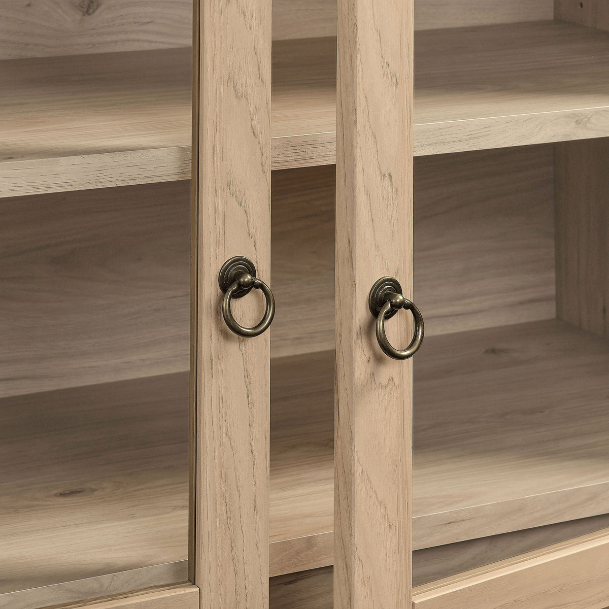Warm brass ring pulls accent the light oak frame and clear glass doors || EEI-7168-LOA || handle_studio
