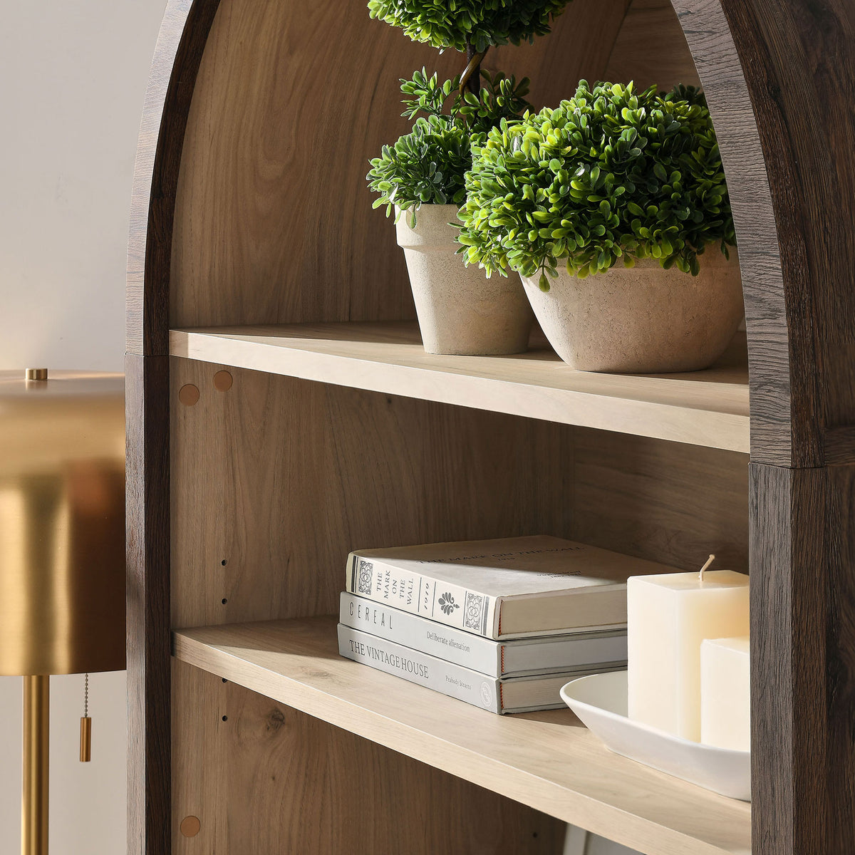 Styled shelves showcase decor against warm wood tones and the graceful arched frame || EEI-7169-WAL-LOA || detail_room