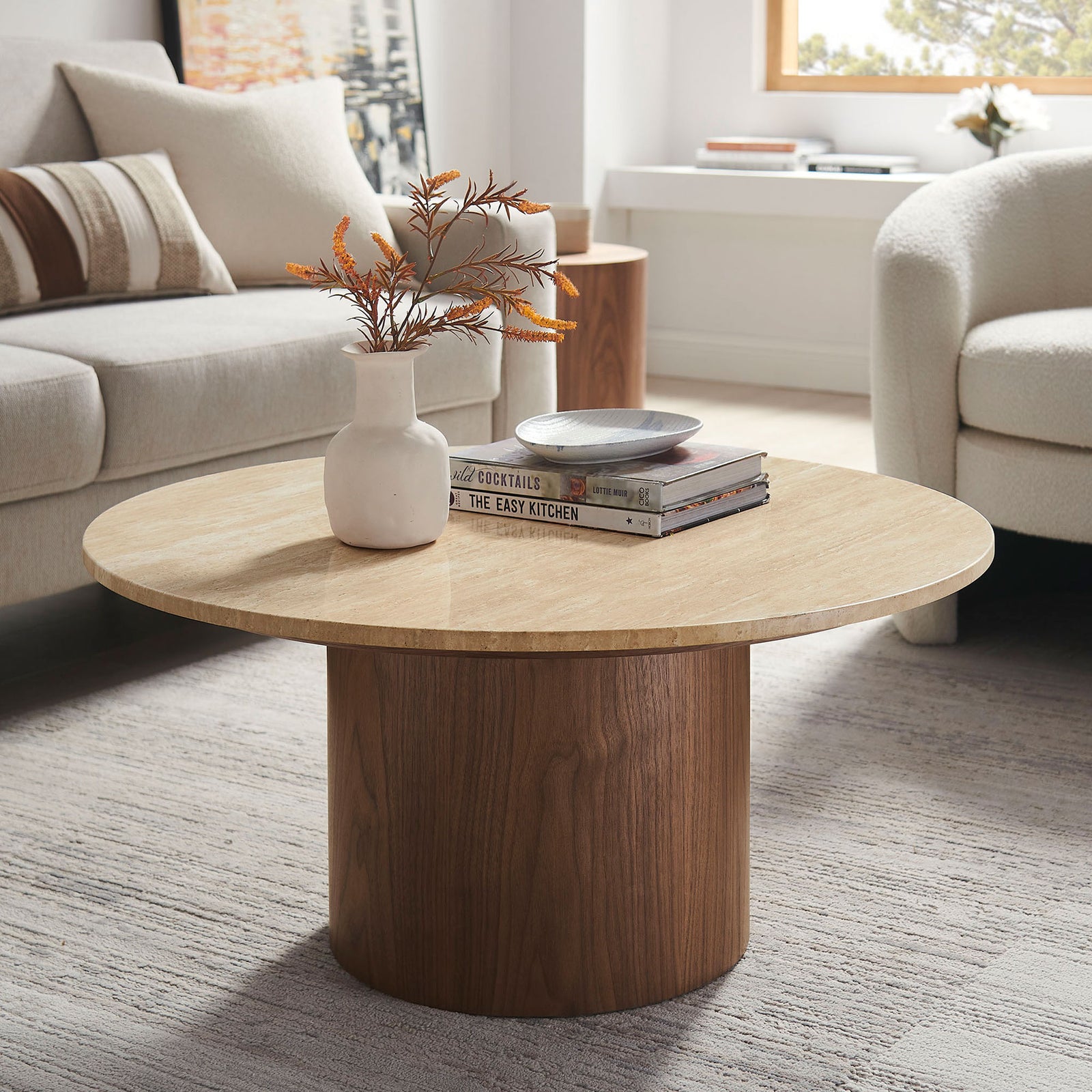 Modern round table blends a natural travertine top with a walnut pedestal for organic, minimalist style || EEI-7170-WAL-TRV || front_angle_room
