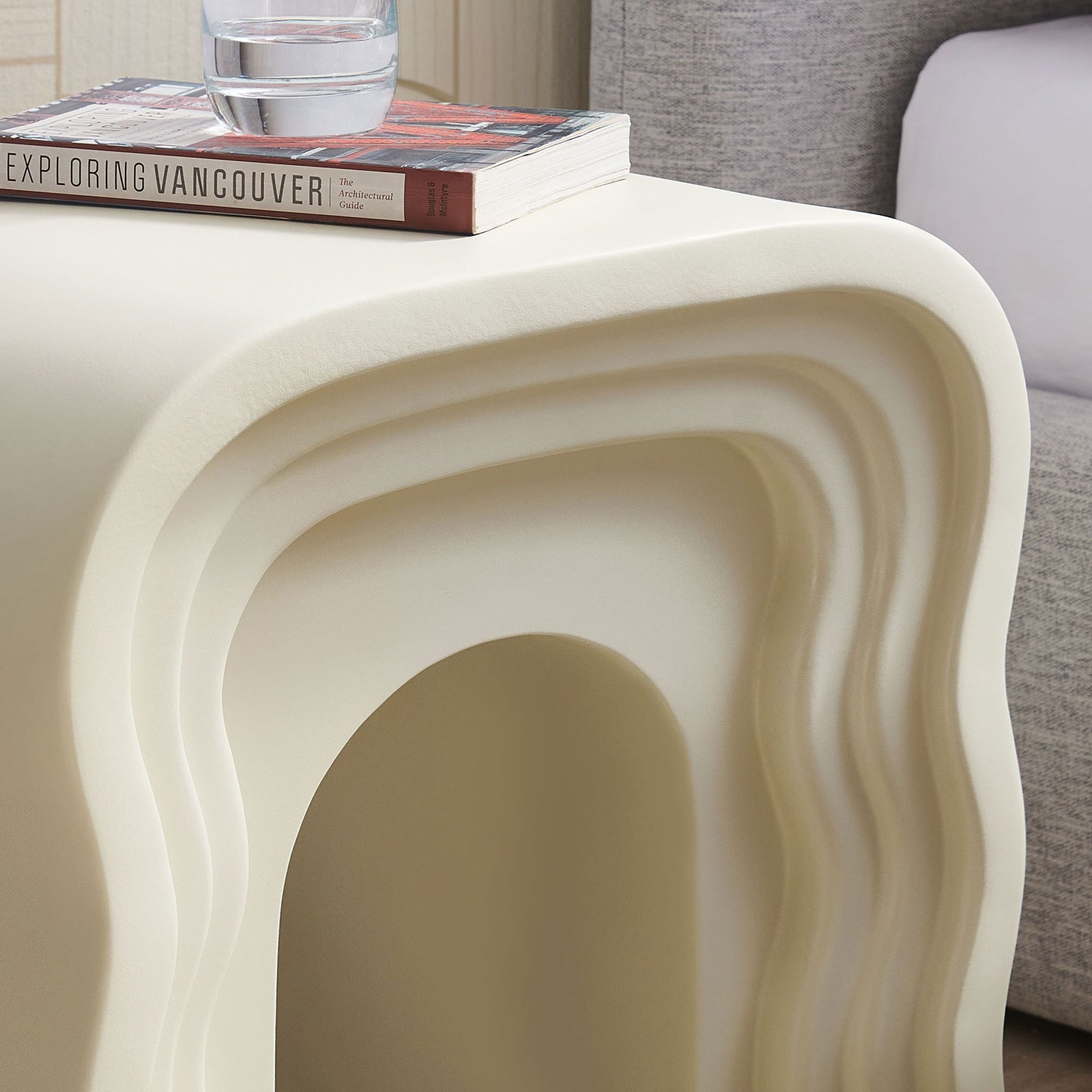 Ivory squiggle side table styled with books and a drink to show everyday use beside the bed || EEI-7171-IVO || detail_room