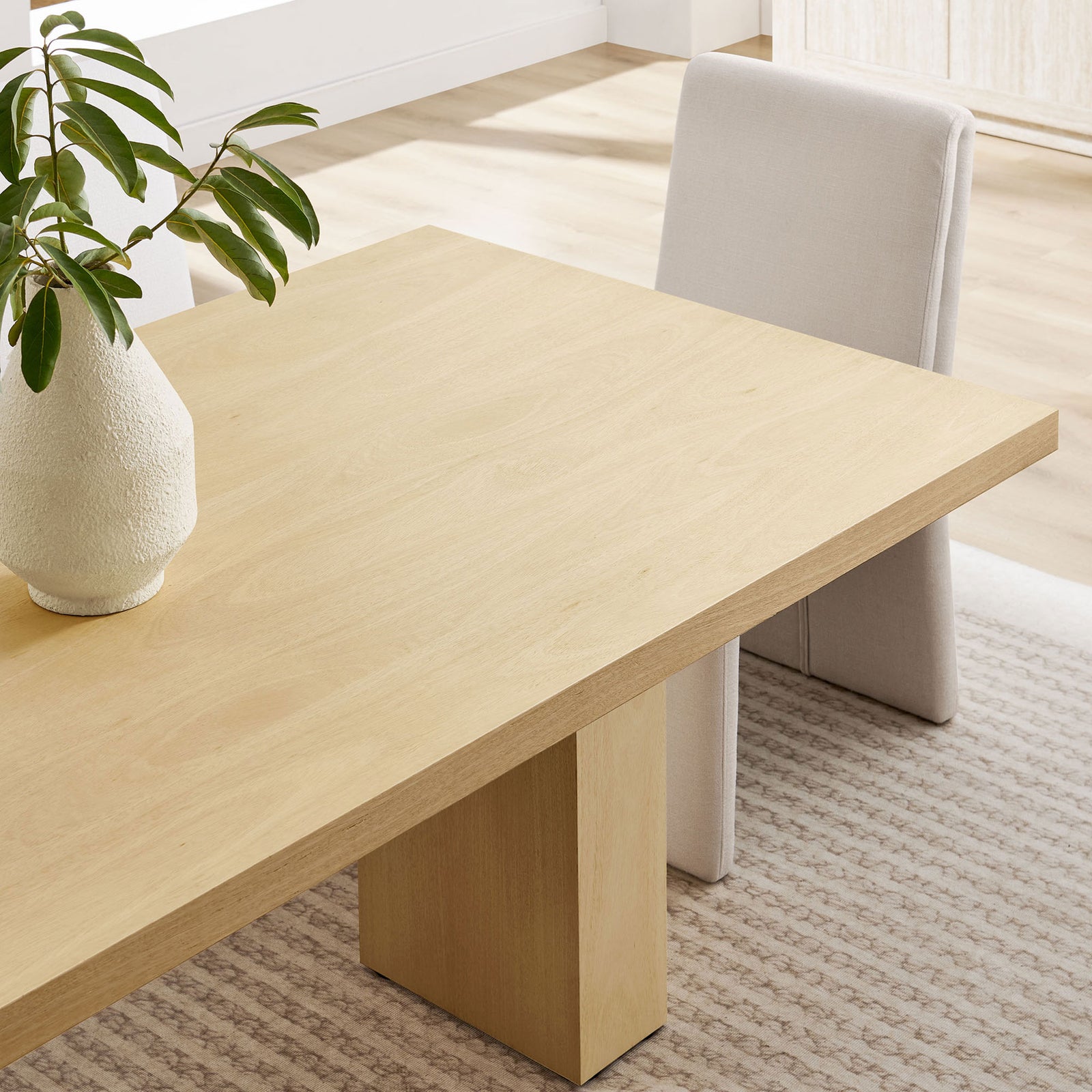 Styled tabletop vignette shows the table paired with soft upholstered seating in a bright dining room || EEI-7173-NAT || detail_room