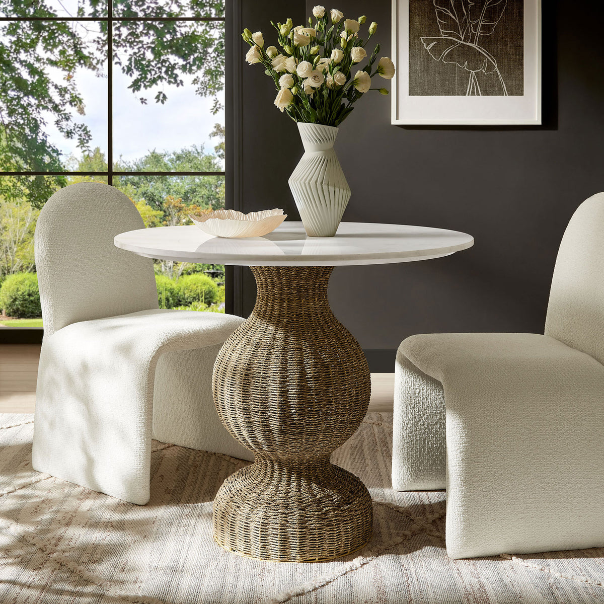 Round marble and seagrass dining table creating a bright coastal focal point in a cozy dining room || EEI-7195-WHI-NAT || front_angle_room