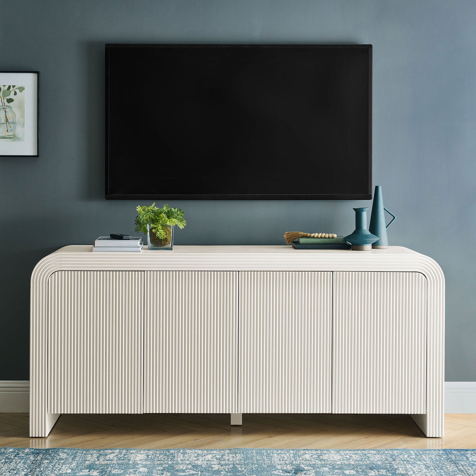 White fluted sideboard used as a media console beneath a wall mounted TV in a modern living room || EEI-7198-IVO || front_room