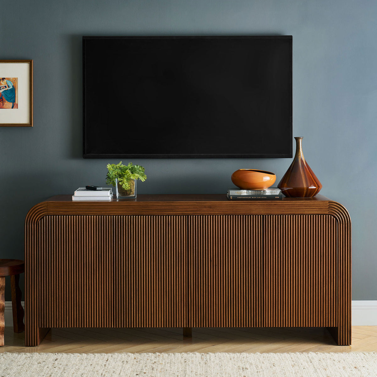 Walnut fluted sideboard doubles as a sleek media console beneath a wall-mounted TV in a contemporary living room || EEI-7198-WAL || front_room