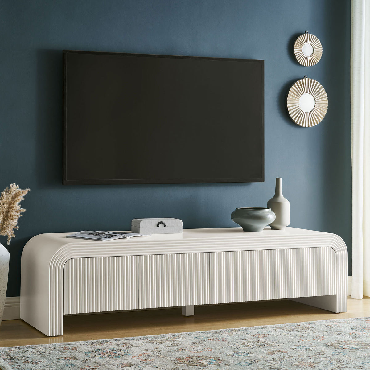 White matte fluted TV stand grounds a chic living room with low profile and generous surface space || EEI-7199-IVO || front_angle_room
