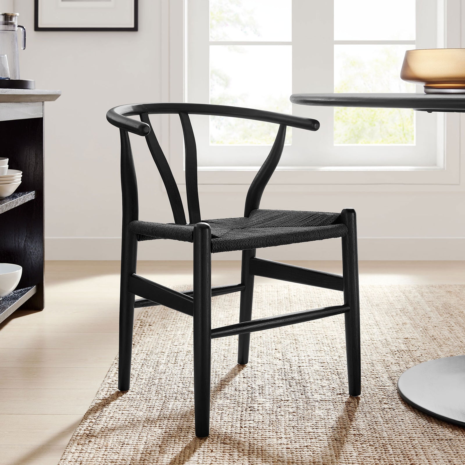 Black Amish dining chair styled in a bright dining room beside a modern round table || EEI-7200-BLK-BLK || front_angle_room