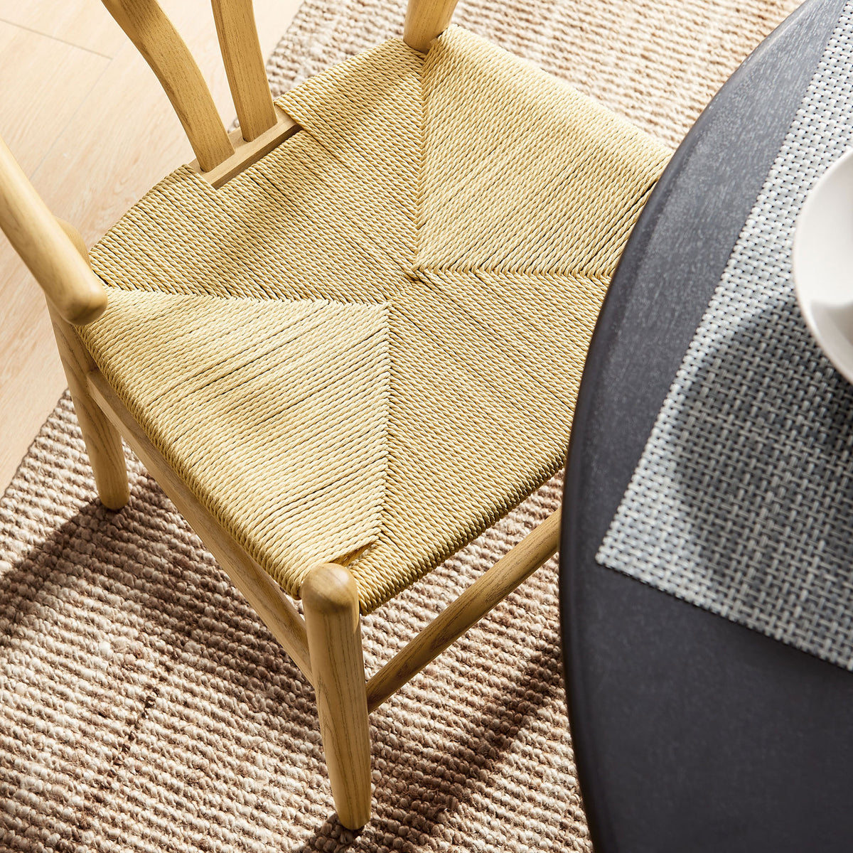 Woven rope seat of the chair styled with a textured rug and modern dining table || EEI-7200-NAT || detail_room