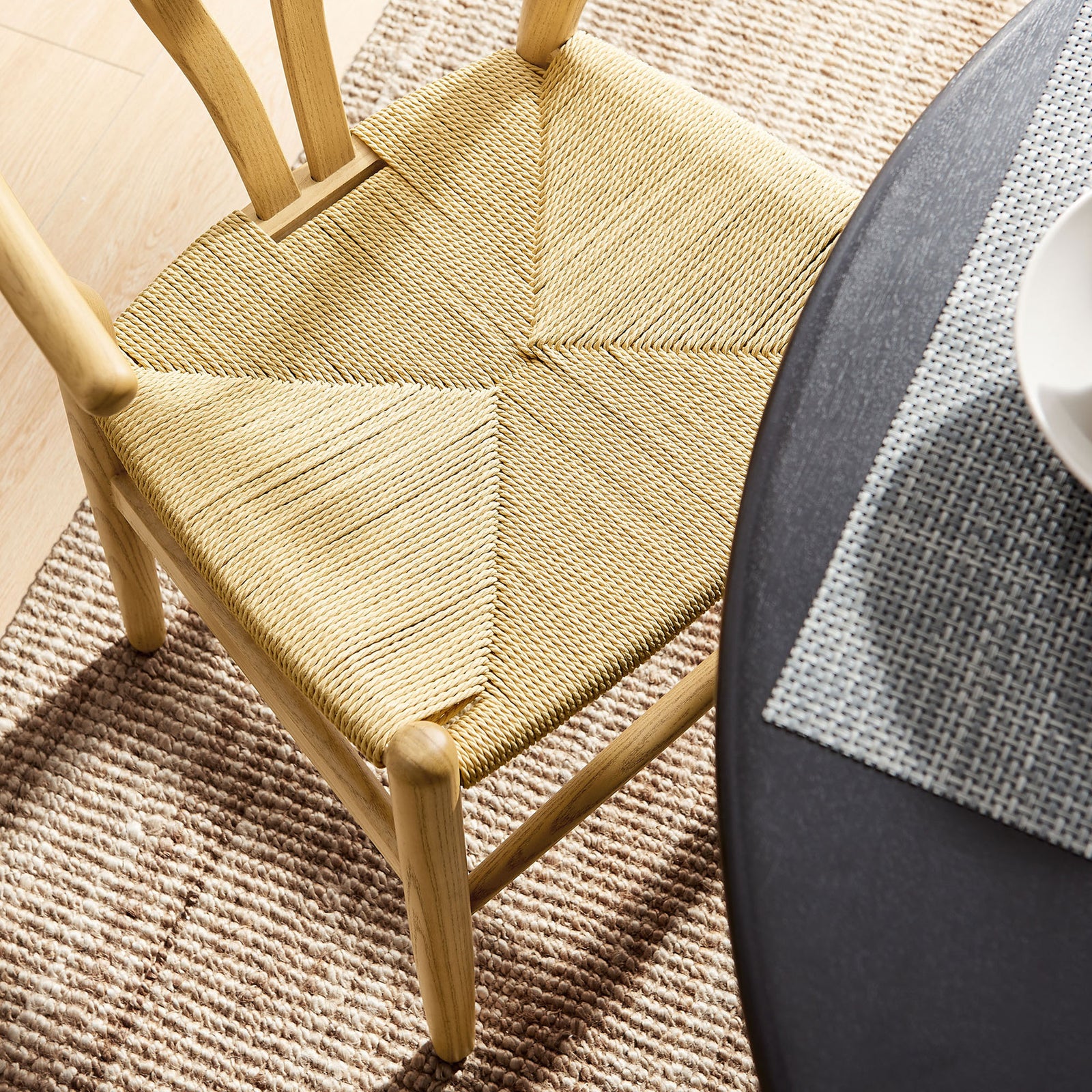 Woven rope seat of the chair styled with a textured rug and modern dining table || EEI-7200-NAT || detail_room