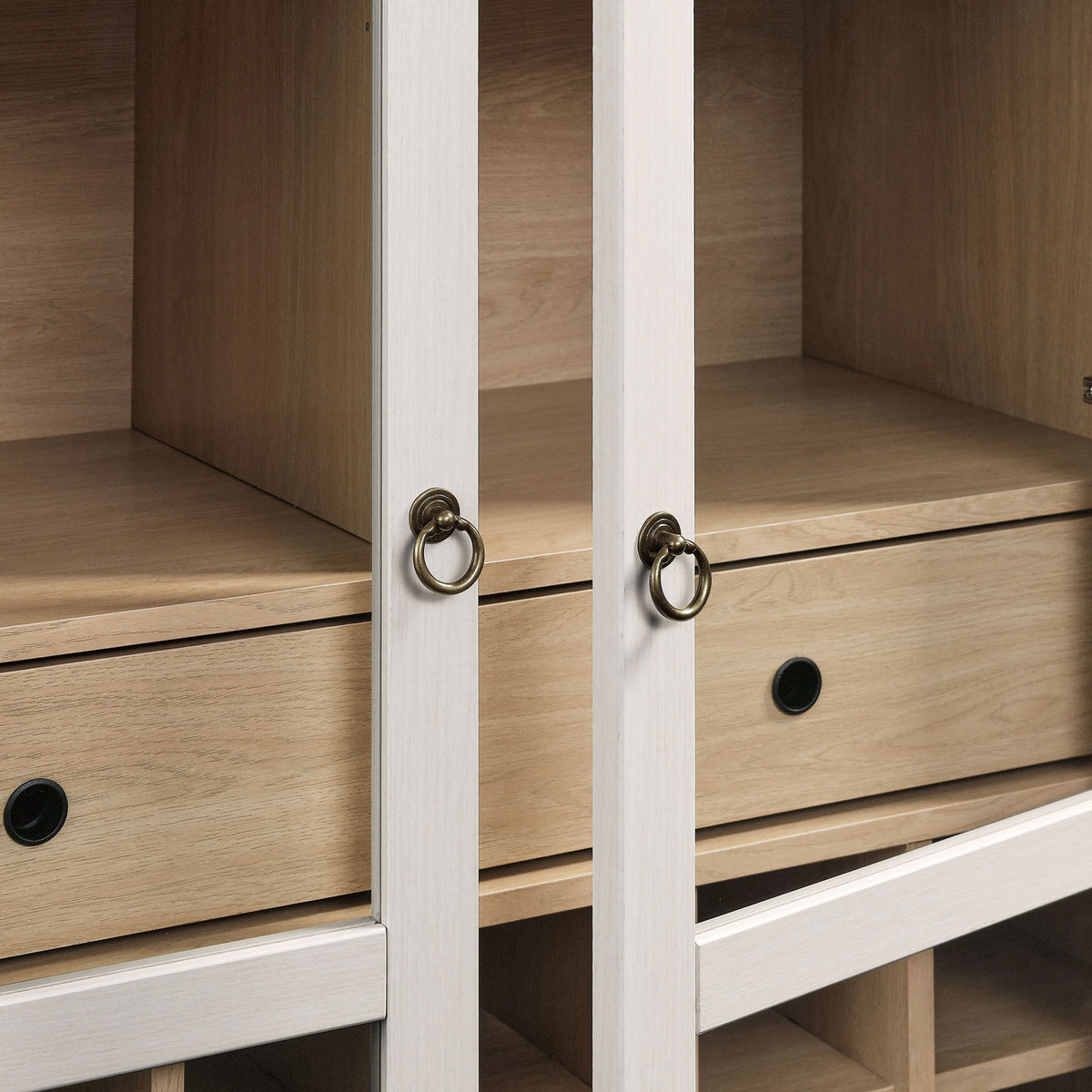 Brushed gold metal ring pulls lend elegant detail to the glass-front cabinet || EEI-7203-IVO-OAK || handle_studio