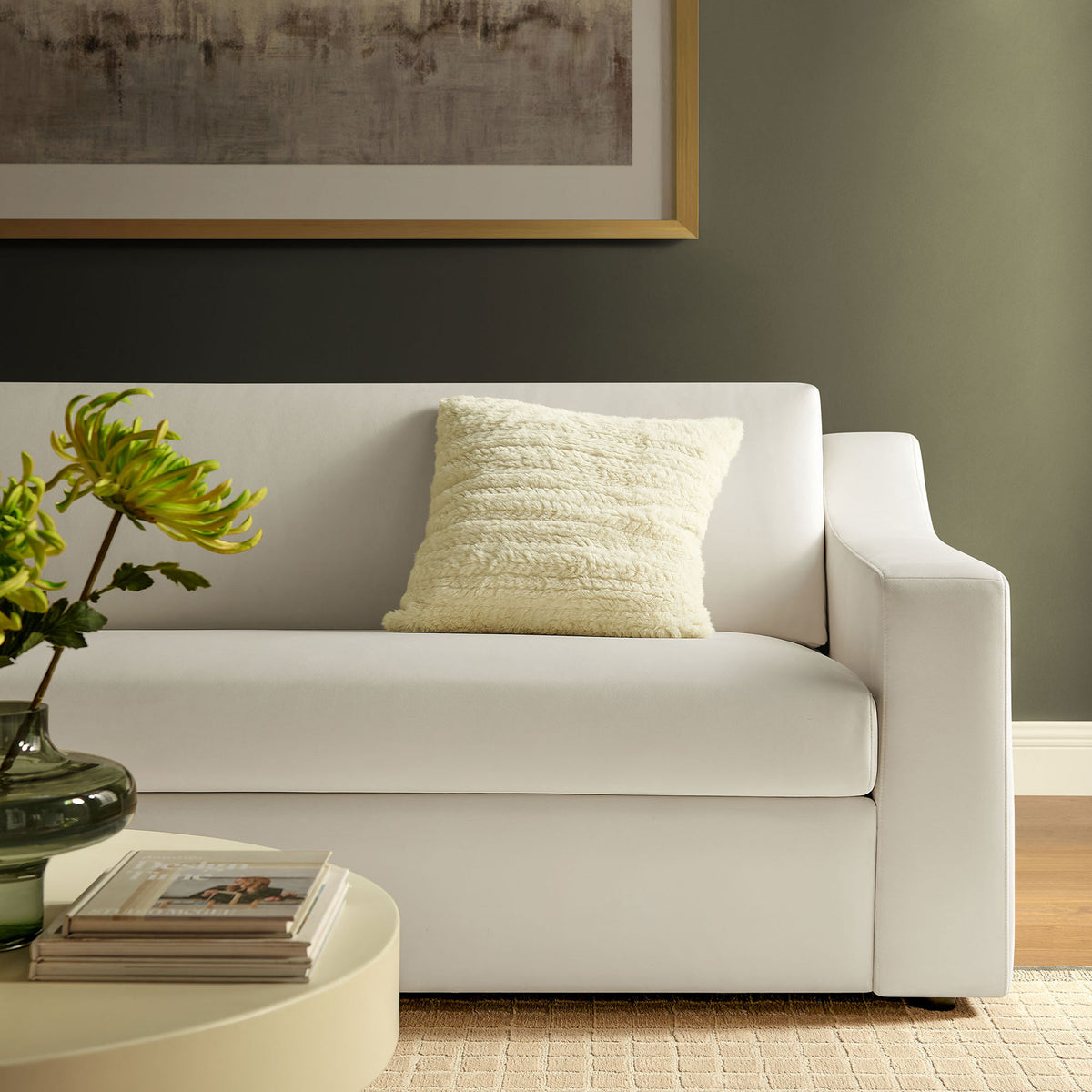 Alabaster velvet sofa styled with textured ivory pillow beside a round coffee table in a warm living space || EEI-7219-ALA || detail_room