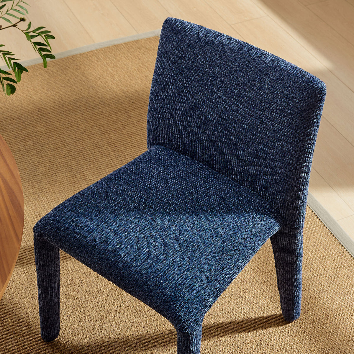 Rhodes navy dining chair bringing cozy texture and inviting comfort to a modern light-filled dining nook. || EEI-7222-NAV || top_angle_room