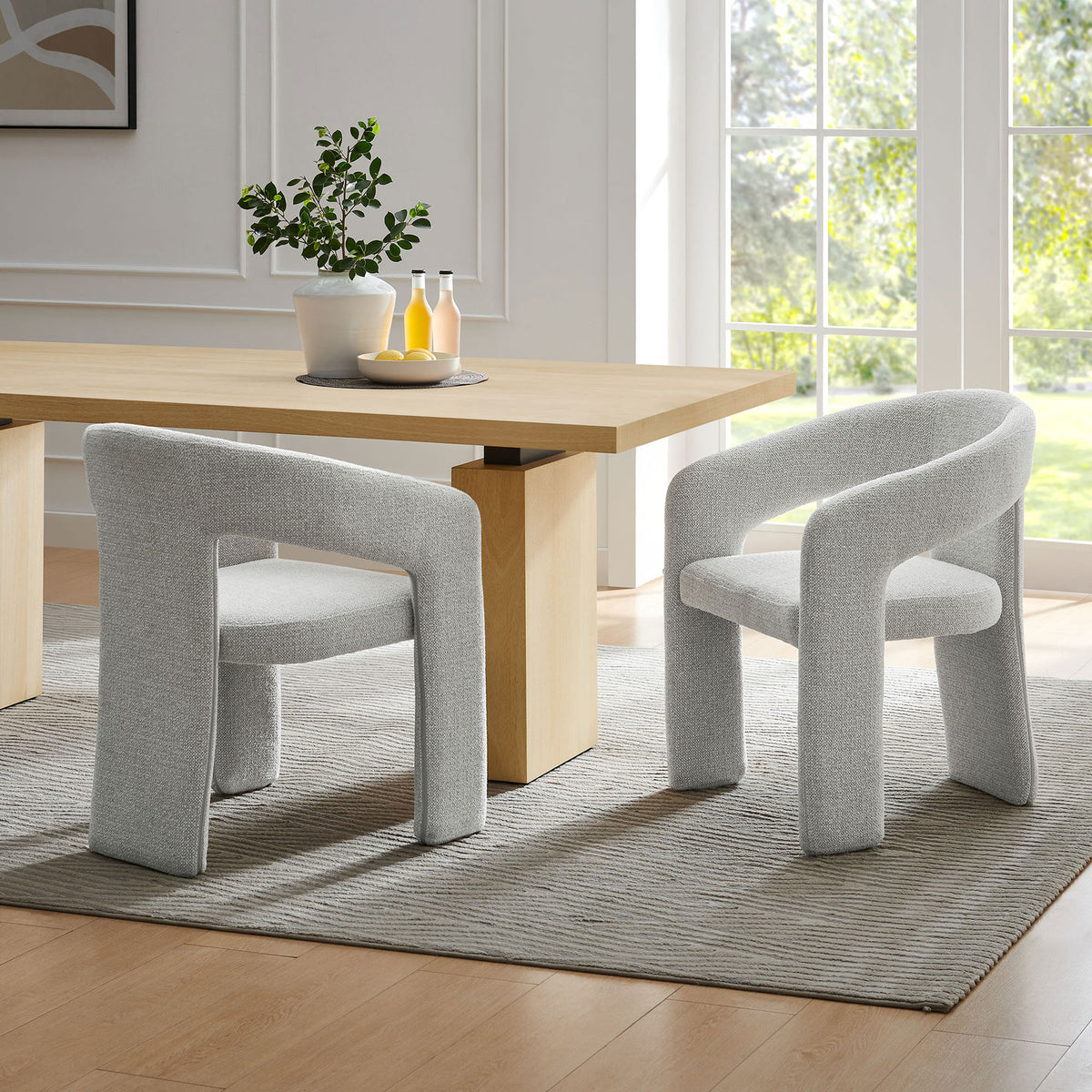 Pair of Oslo dove gray barrel chairs flanking a light wood dining table in a bright airy room || EEI-7224-DOV || front_angle_room