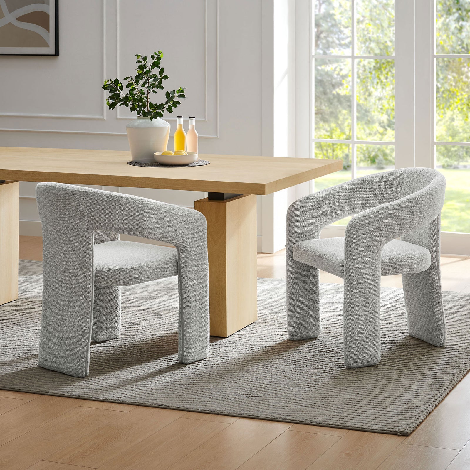 Pair of Oslo dove gray barrel chairs flanking a light wood dining table in a bright airy room || EEI-7224-DOV || front_angle_room