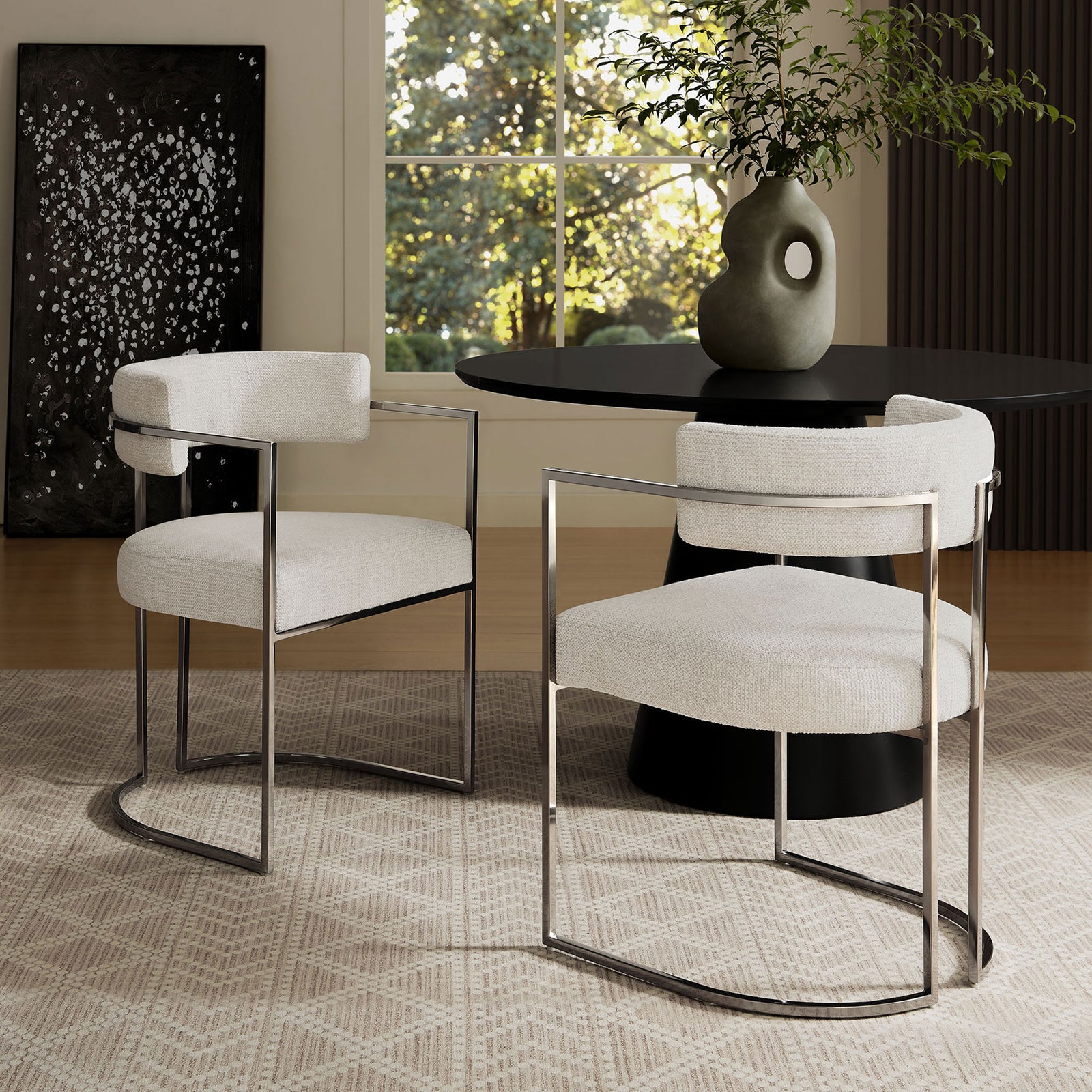 Pair of modern barrel-back dining chairs with chrome sled bases surrounding a round pedestal table || EEI-7228-SLV-CRE || front_angle_room