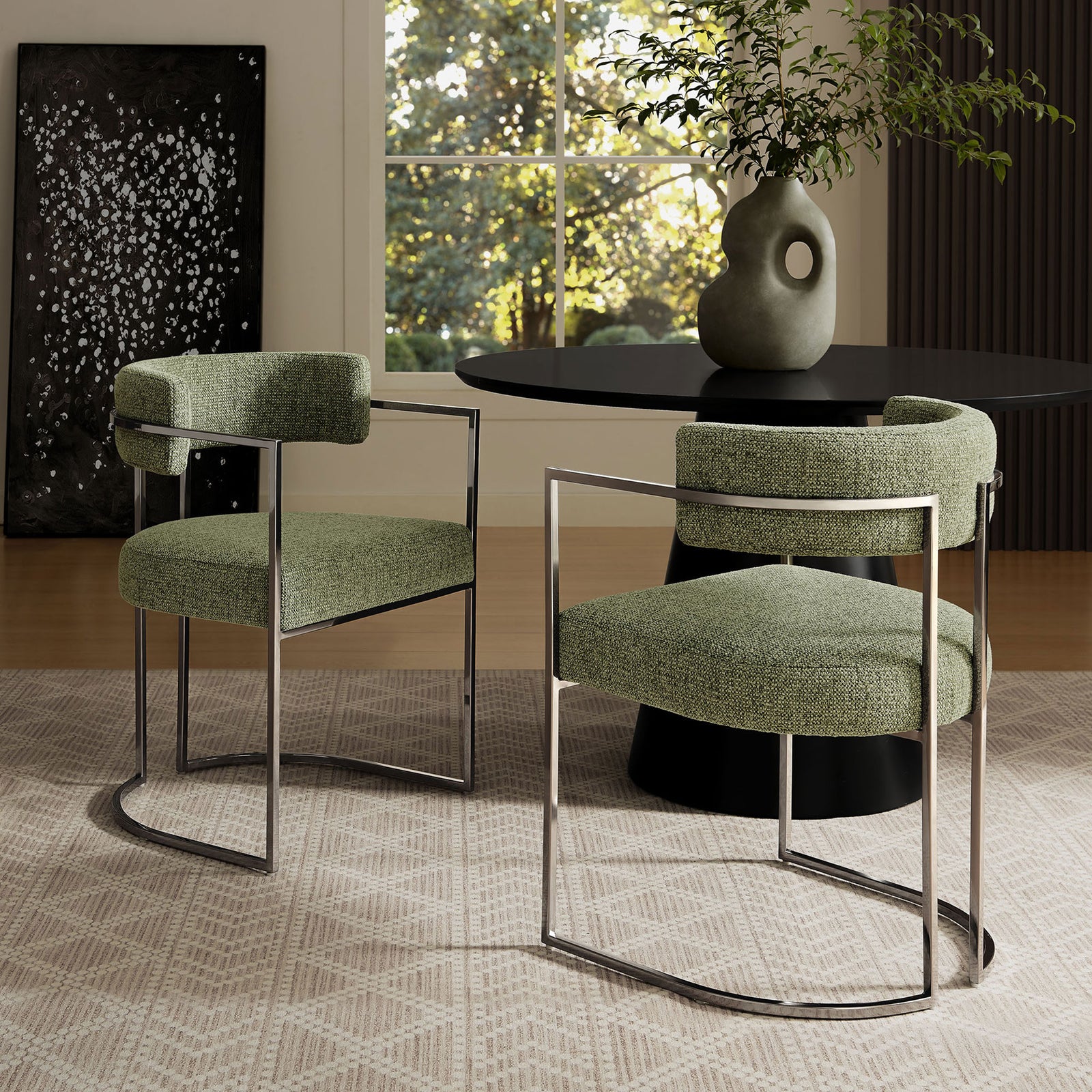 Pair of Huron dining chairs around a black pedestal table in a sunlit contemporary room || EEI-7228-SLV-LEA || front_angle_room