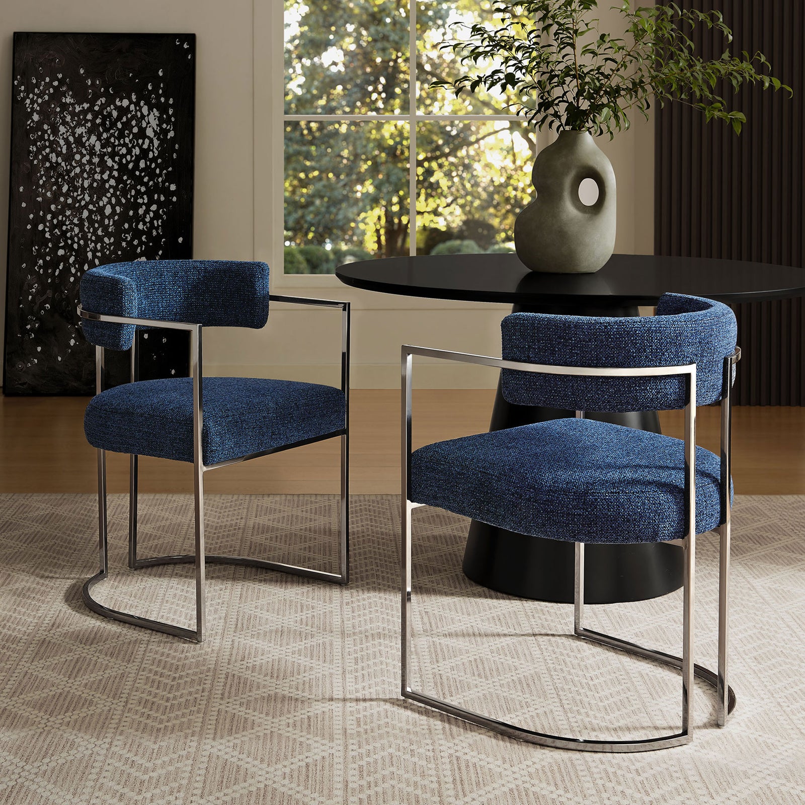 Pair of navy barrel-back dining chairs around a modern black pedestal table. || EEI-7228-SLV-NAV || front_angle_room