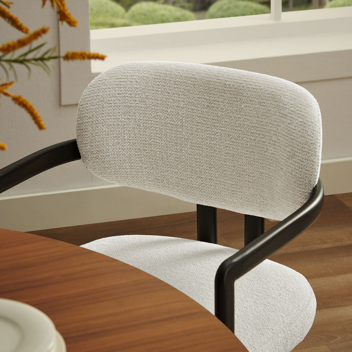 Cream barrel back chair brings soft texture and comfort to a modern light-filled dining space || EEI-7229-BLK-CRE || detail_room