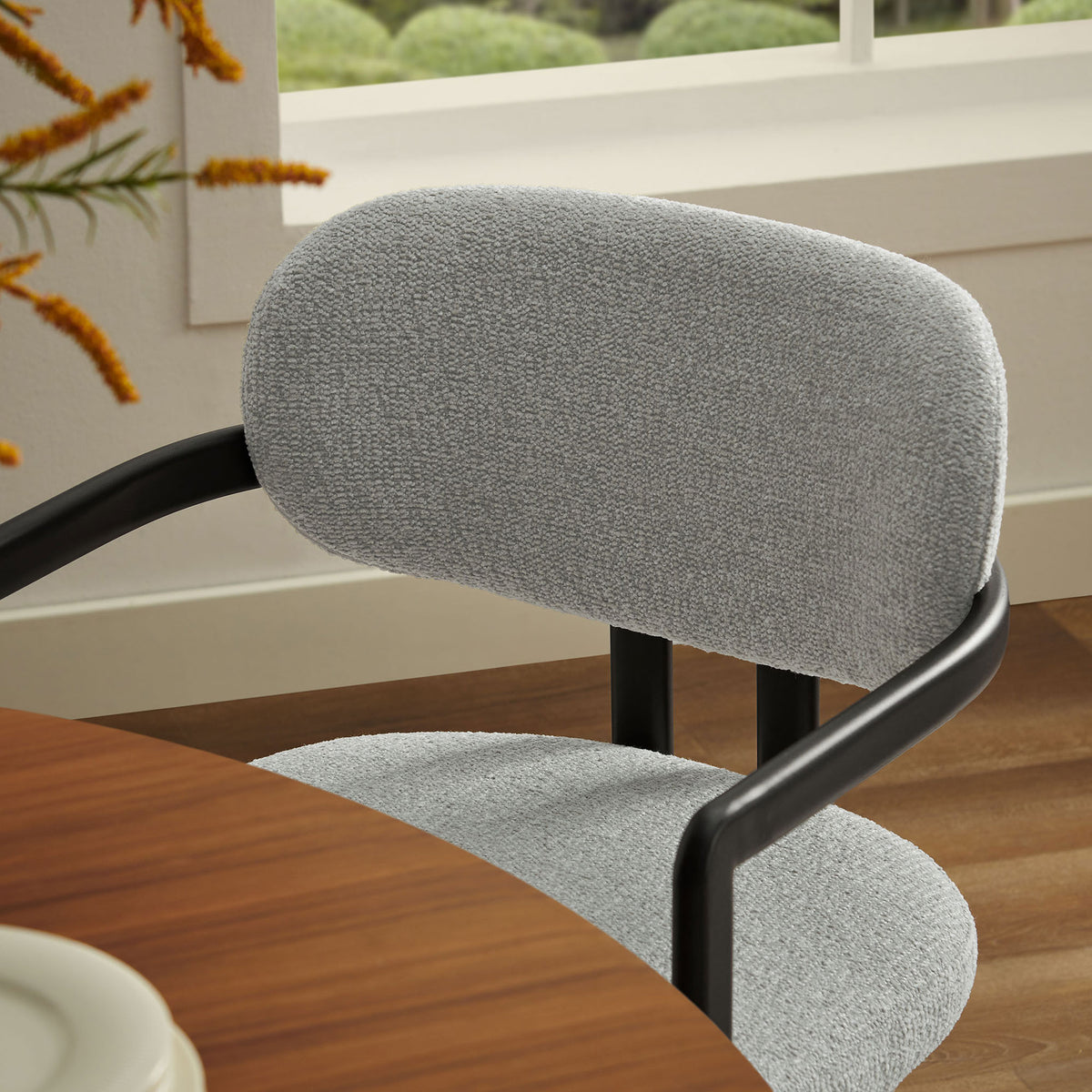 Soft gray backrest and black arm of Elio chair next to a tabletop arrangement in a modern dining space || EEI-7229-BLK-DOV || detail_room
