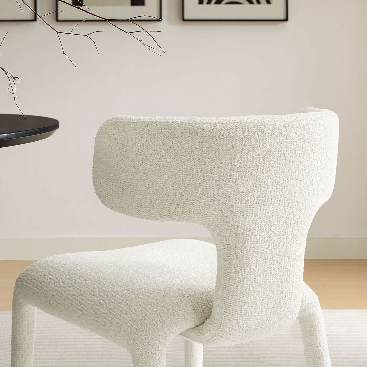 Cream boucle dining chair at a modern dining table, showcasing its curved back and cozy texture || EEI-7230-CRE || detail_room