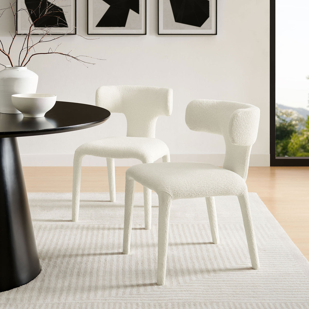 Pair of cream boucle dining chairs in a bright dining room, adding soft texture to a modern table || EEI-7230-CRE || front_angle_multi_room