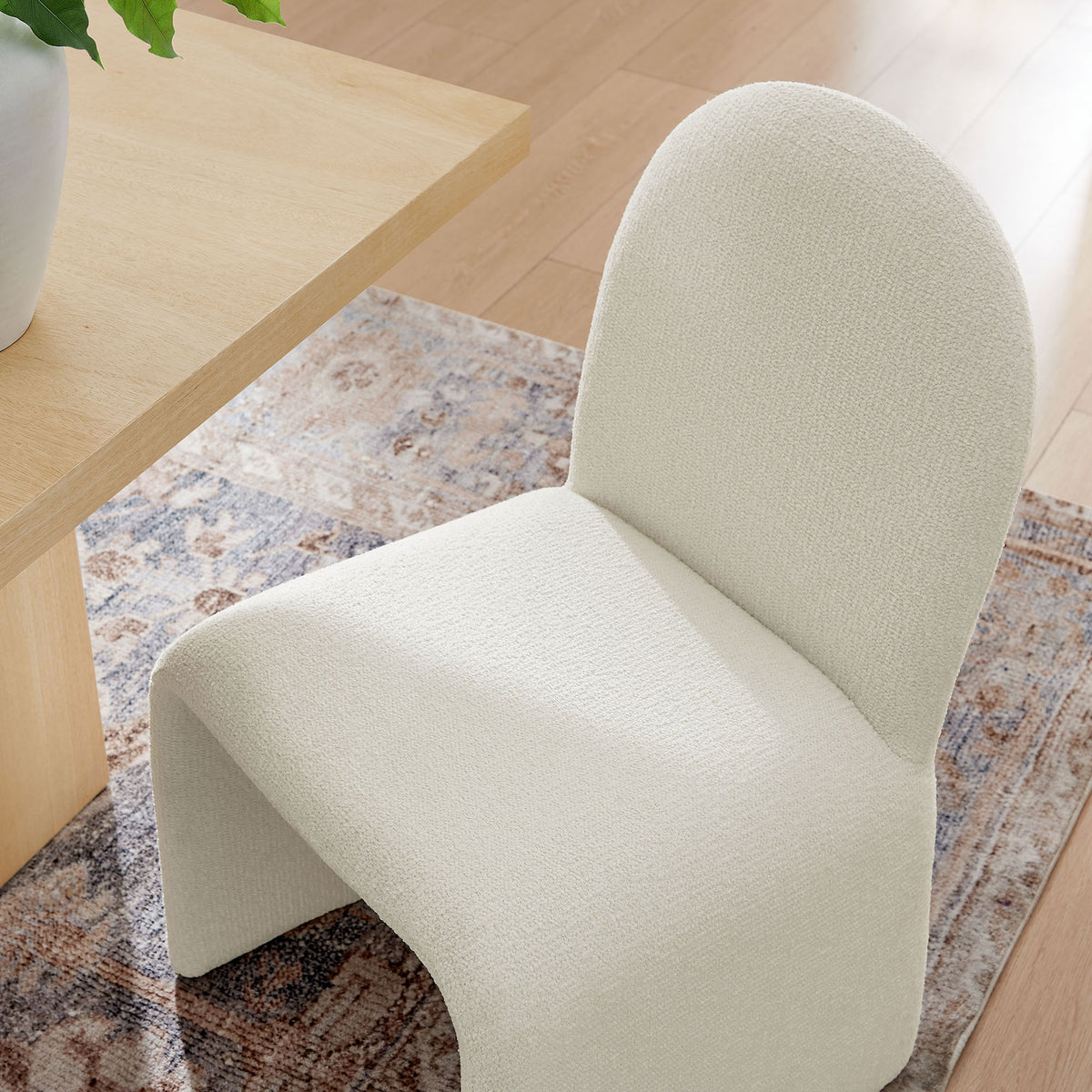 Cream boucle dining chair tucked at a light wood table, adding soft texture to the dining space || EEI-7231-CRE || detail_room