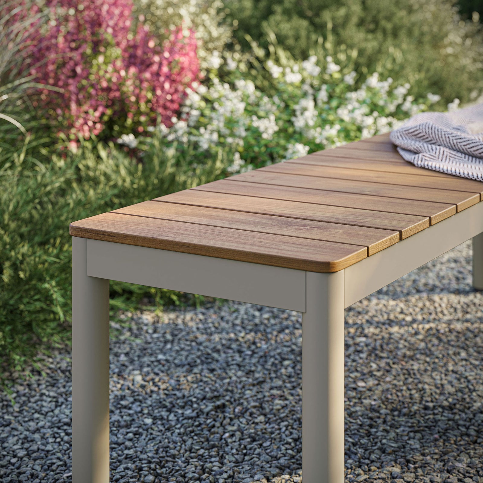 Finn outdoor bench with natural-look slatted top styled on a gravel patio beside lush greenery || EEI-7238-NAT || detail_room