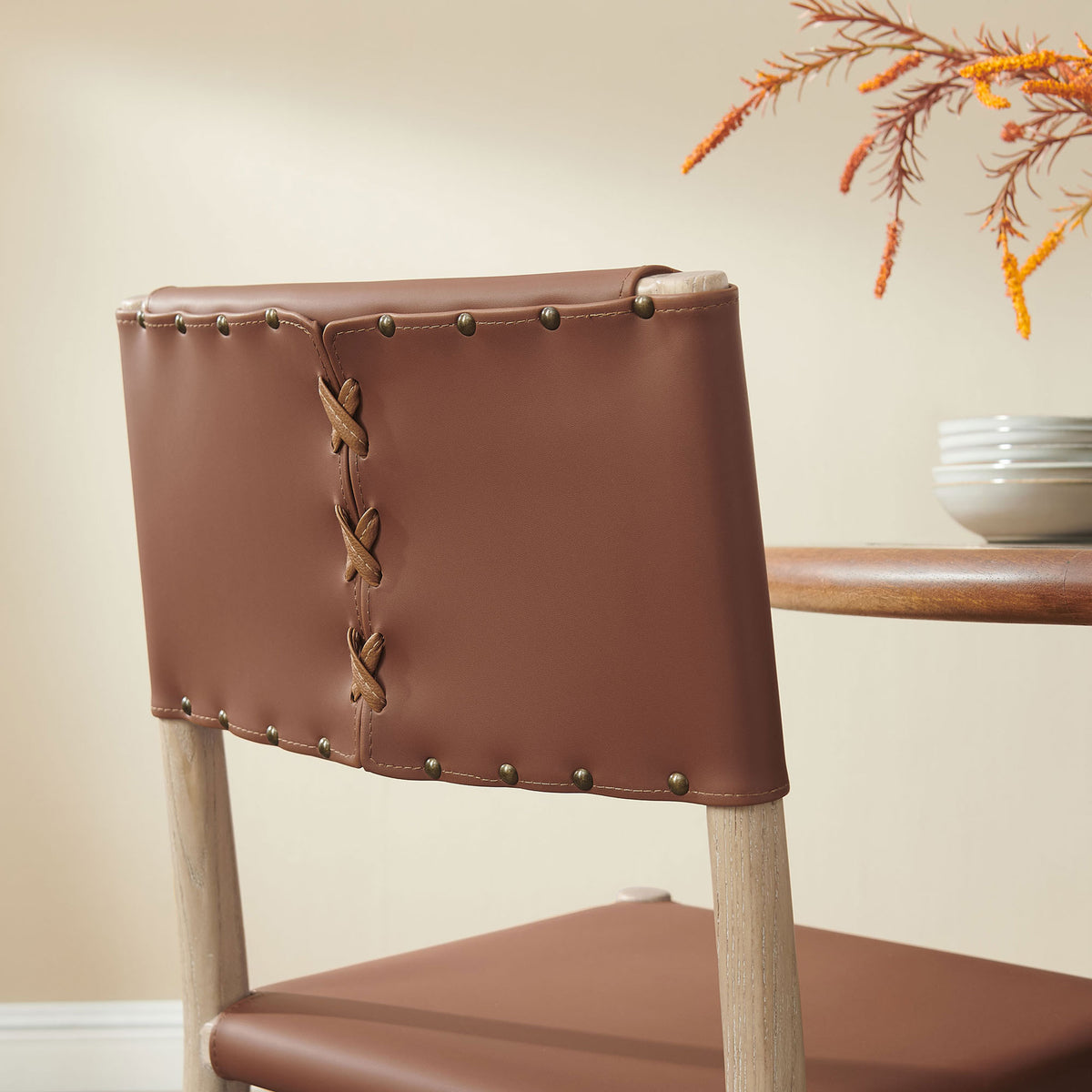 Vegan leather backrest with laced seam and brass-tone studs adds rustic charm alongside your dining table || EEI-7240-NAT-SDL || detail_room