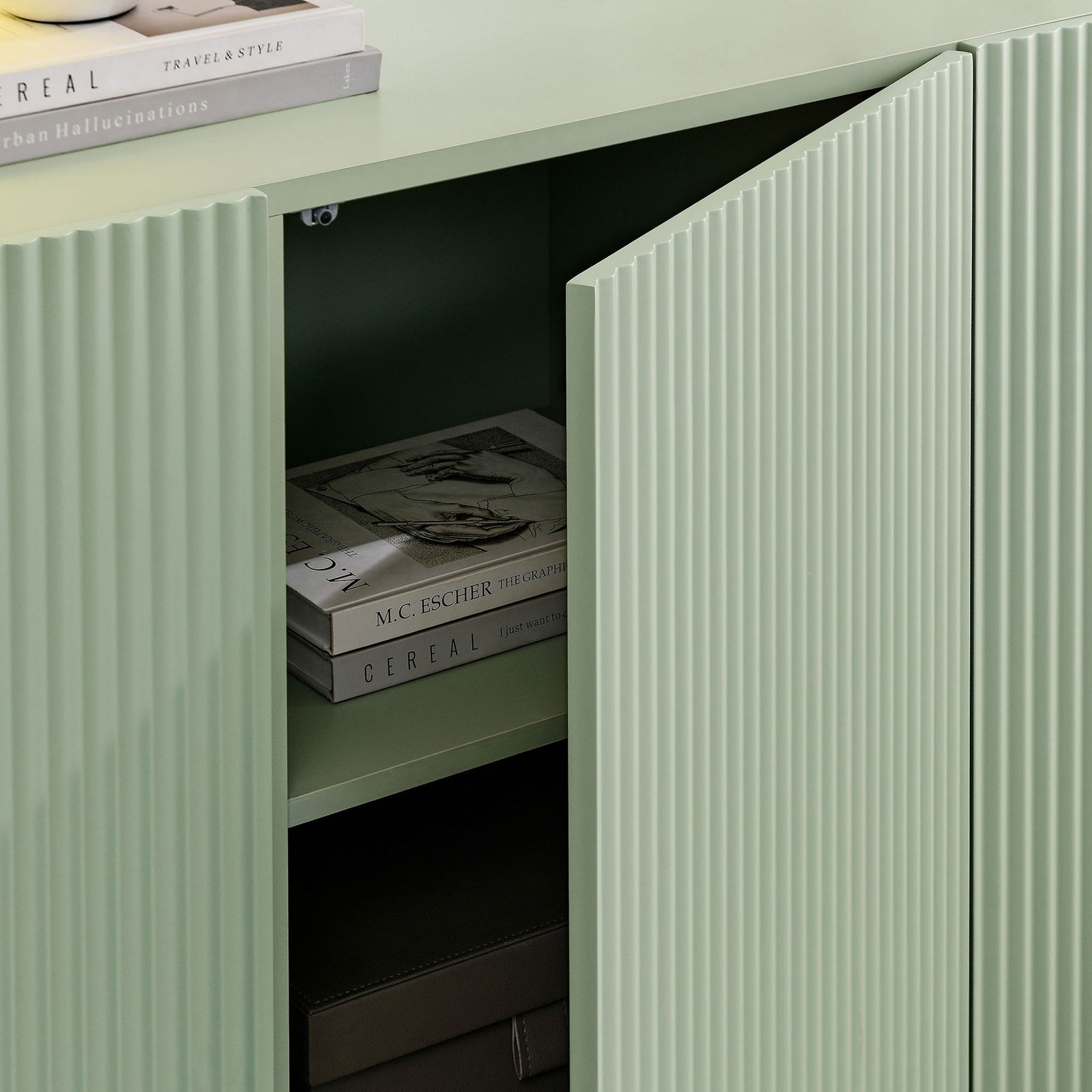 Dahlia sideboard in sage green with door ajar to reveal adjustable shelving storing books and boxes || EEI-7241-SGE || storage_open_room