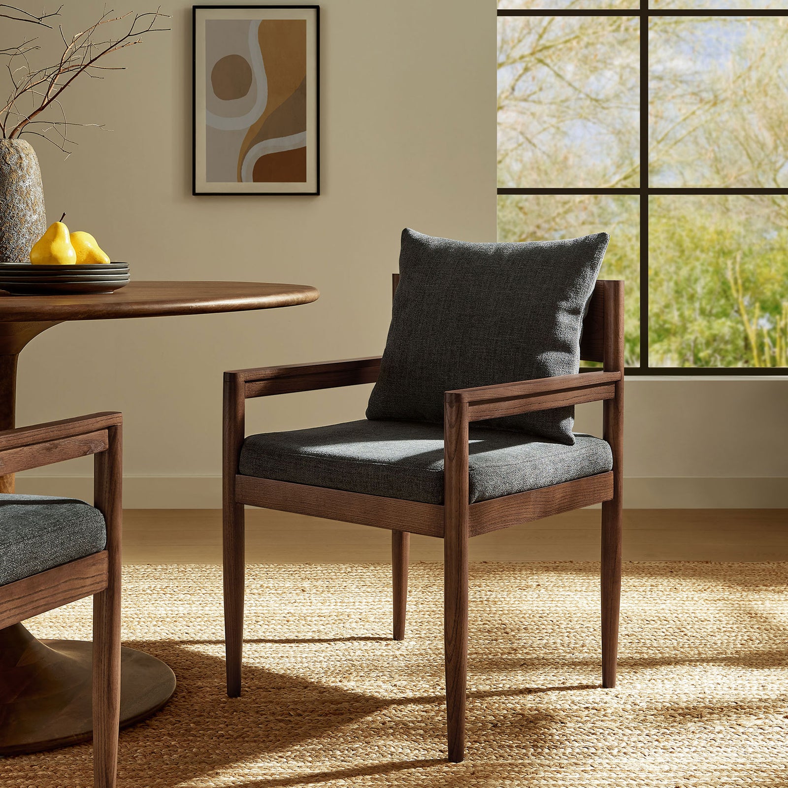 Charcoal upholstered Remington dining armchair styled in a bright dining room with round table || EEI-7243-CHA || front_angle_room