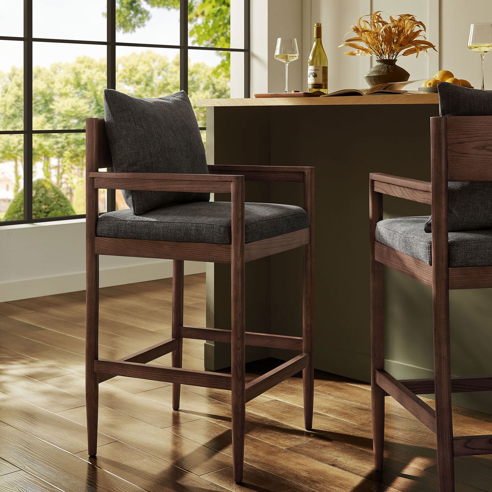 Modern warmth for the bar, with a rich elm frame and a charcoal cushion that invites lingering. || EEI-7245-CHA || front_angle_room
