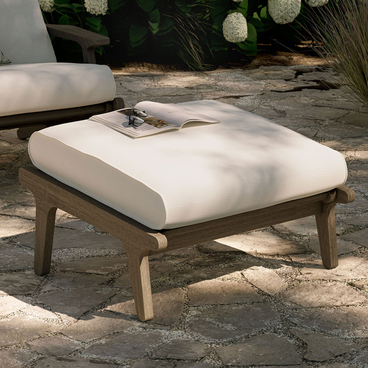 White cushioned teak ottoman arranged outdoors as a chic footrest and inviting extra patio seat || EEI-7250-WGR-WHI || front_angle_room