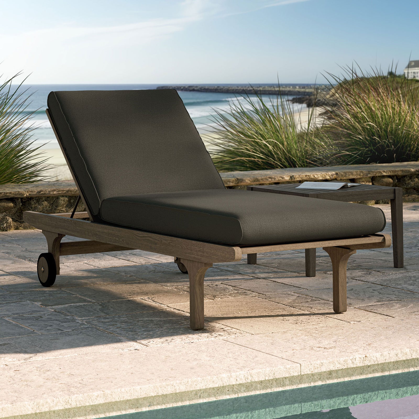 Flint gray cushioned teak chaise lounge styled by a sunlit pool for sophisticated outdoor relaxation || EEI-7251-WGR-FLI || front_angle_room
