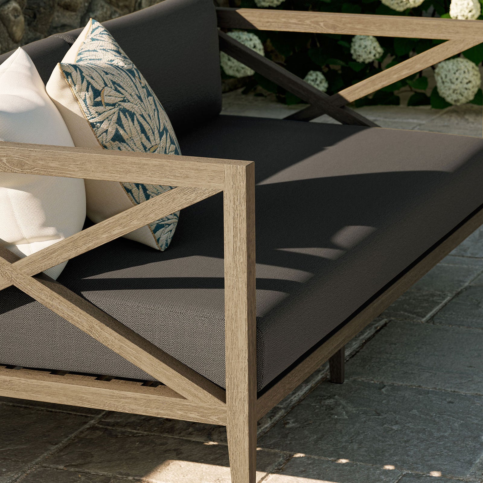 Teak arm and flint gray seat cushions styled with accent pillows create an inviting outdoor lounge moment. || EEI-7254-WGR-FLI || detail_room