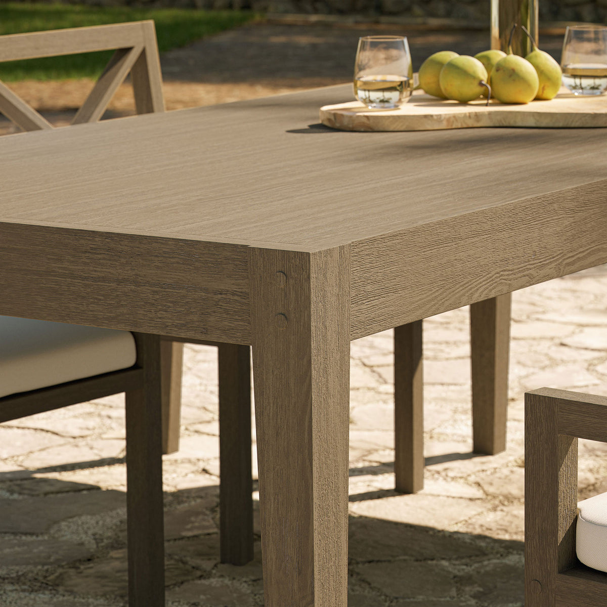 Outdoor patio dining table corner styled with drinks and fruit, emphasizing the warm weathered gray teak || EEI-7257-WGR || detail_room