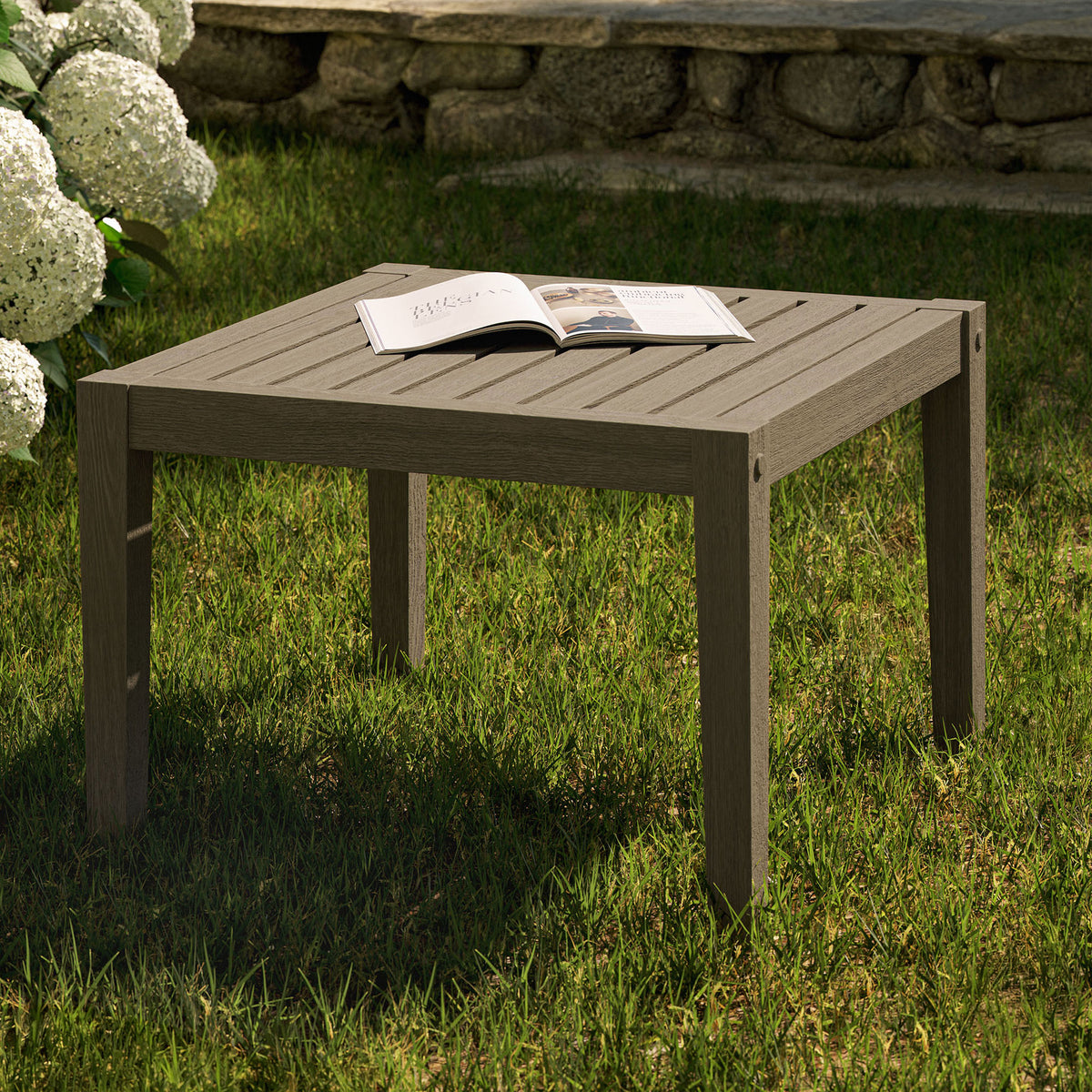 Weathered gray teak side table on a lush lawn, perfect for drinks, books, and decor in outdoor seating areas. || EEI-7258-WGR || front_angle_room