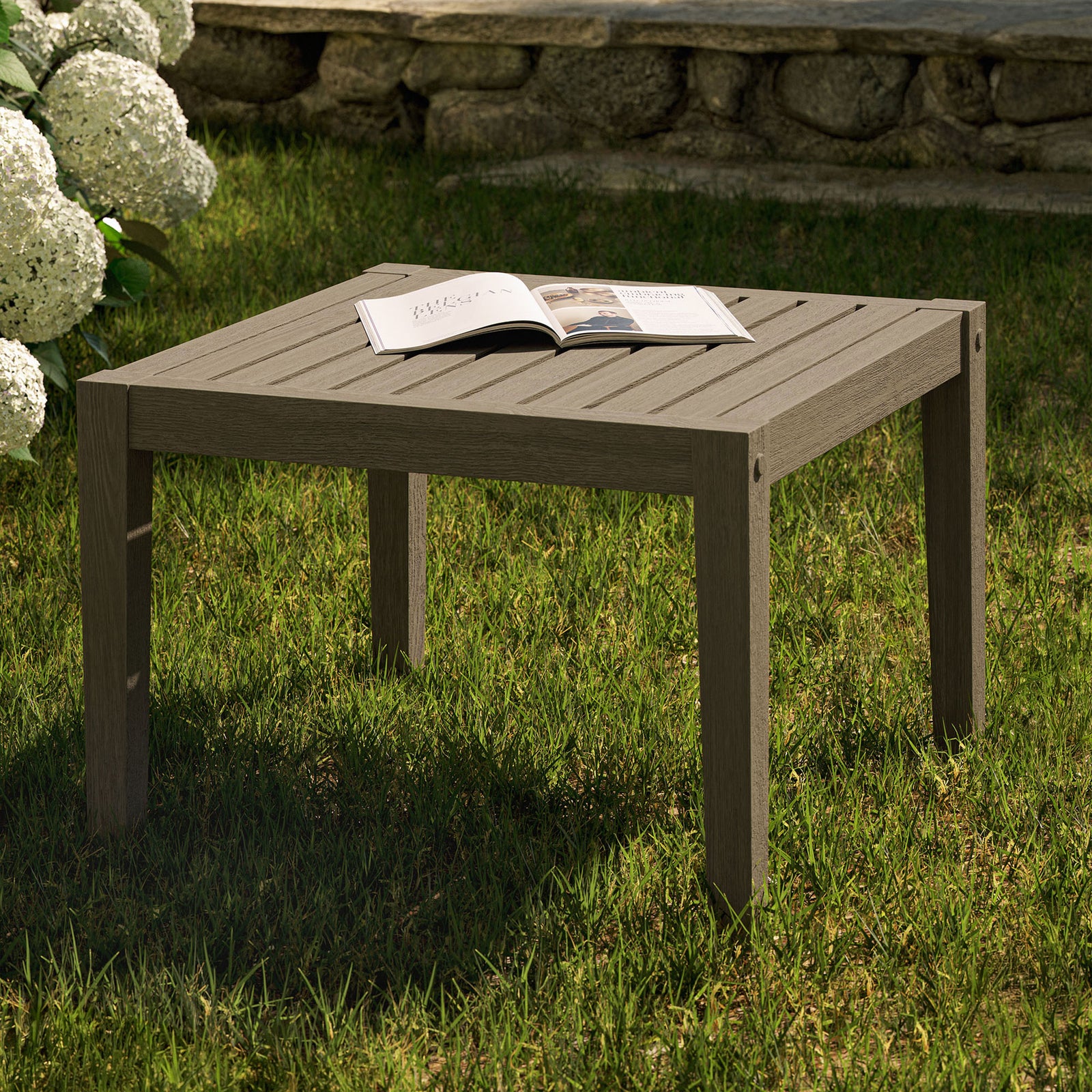 Weathered gray teak side table on a lush lawn, perfect for drinks, books, and decor in outdoor seating areas. || EEI-7258-WGR || front_angle_room