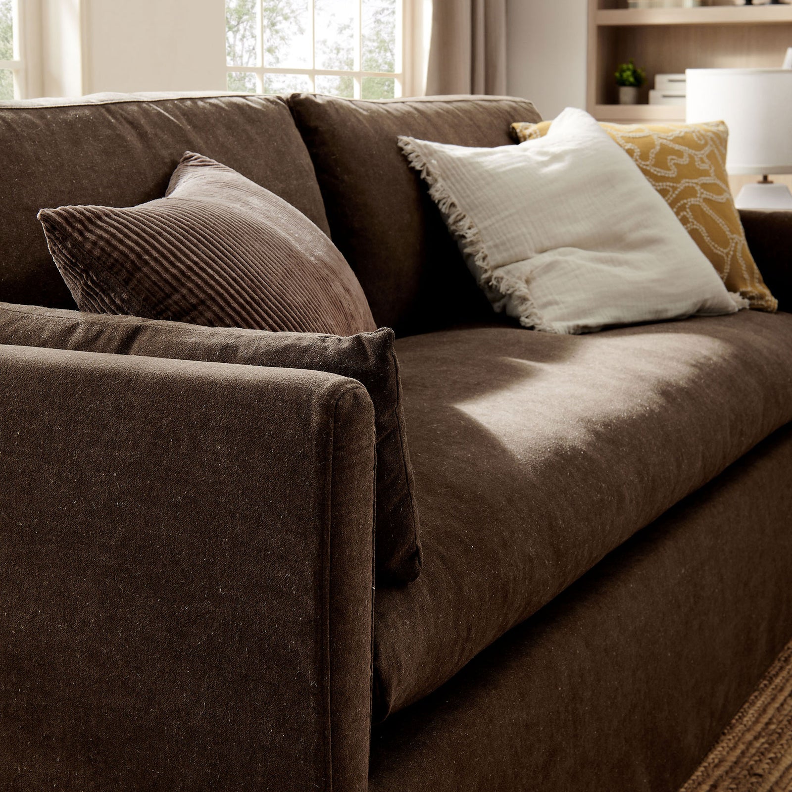 Wellfleet cocoa sofa styled with layered throw pillows, highlighting the plush seat and cozy lounge-ready comfort. || EEI-7260-COA || detail_room