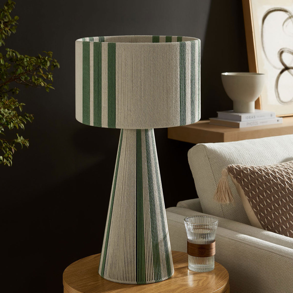 Basil green striped cotton table lamp styling a side table with warm, modern character. || EEI-7262-BAS || front_angle_room