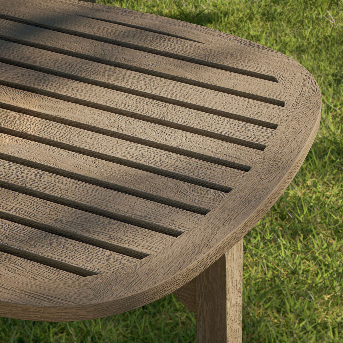 Slatted weathered gray teak tabletop of the Saratoga side table set over a lush green lawn || EEI-7263-WGR || detail_room