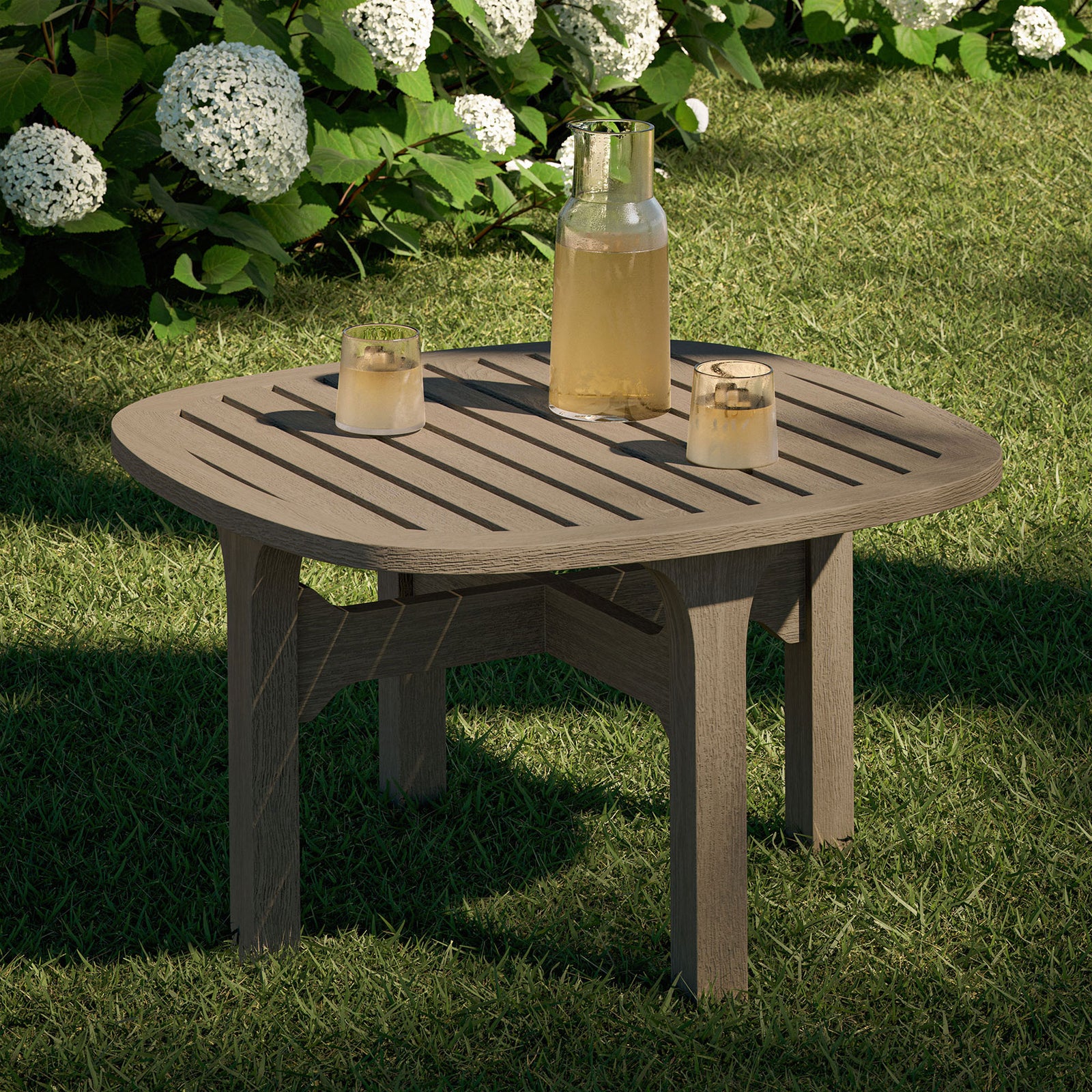 Saratoga weathered gray teak patio side table styled outdoors with drinks and candles on a green lawn || EEI-7263-WGR || front_angle_room
