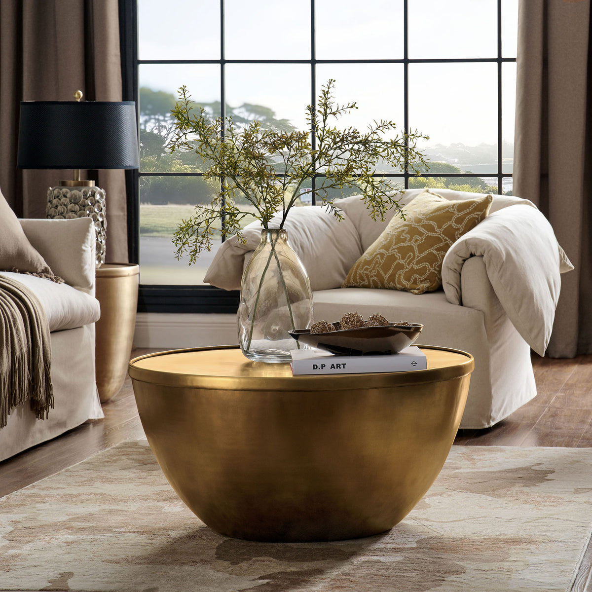 Elegant burnished brass centerpiece anchors the room with a warm glow and minimalist drum silhouette || EEI-7277-BBR || front_angle_room